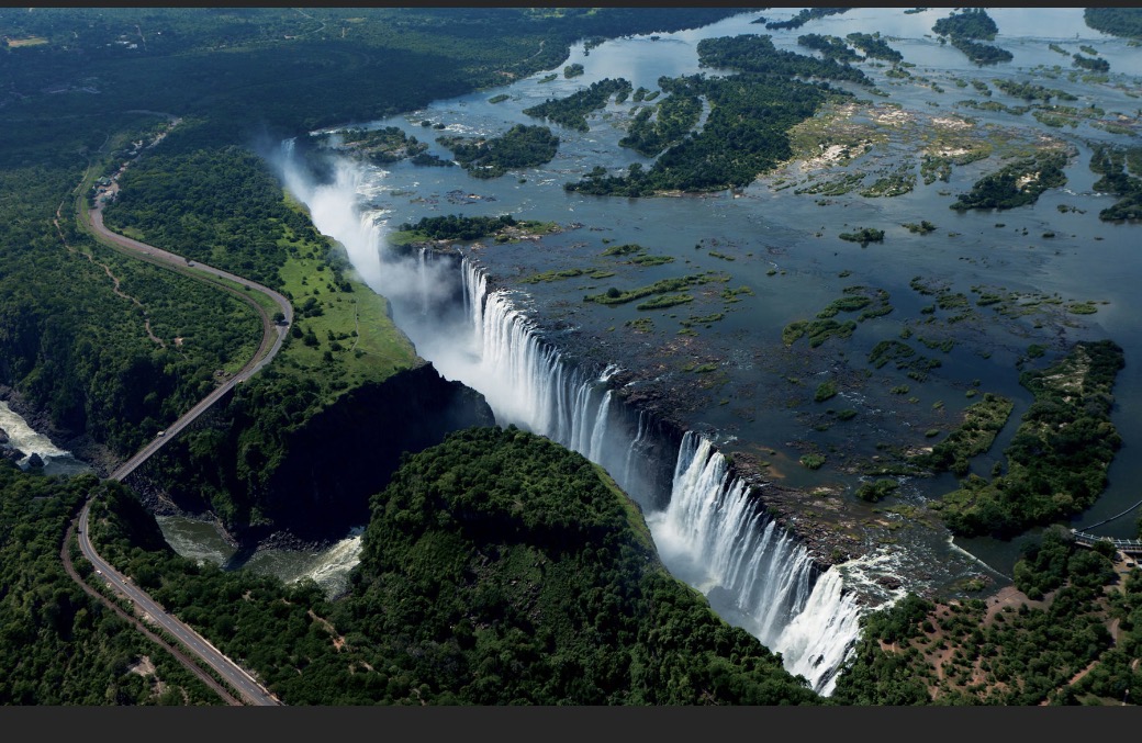 Aerial view of Victoria Falls and the Zambezi gorge, with the Victoria Falls Bridge crossing the canyon
