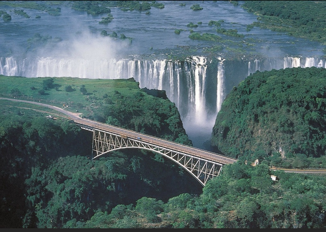The Victoria Falls Bridge arching across the gorge with the waterfall falling behind it